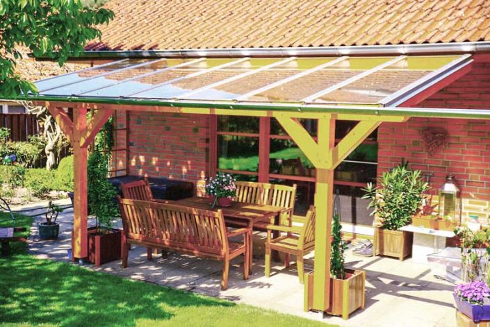 Terrassendach aus Holz mit Glasfeldern an einem Backsteinhaus